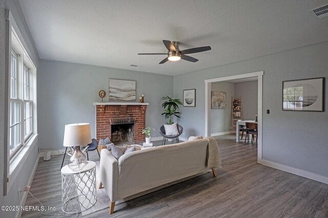 304 Lawton Ave, Jacksonville, FL 32208 - living room featuring wood finished floors, baseboards, ceiling fan, and a fireplace