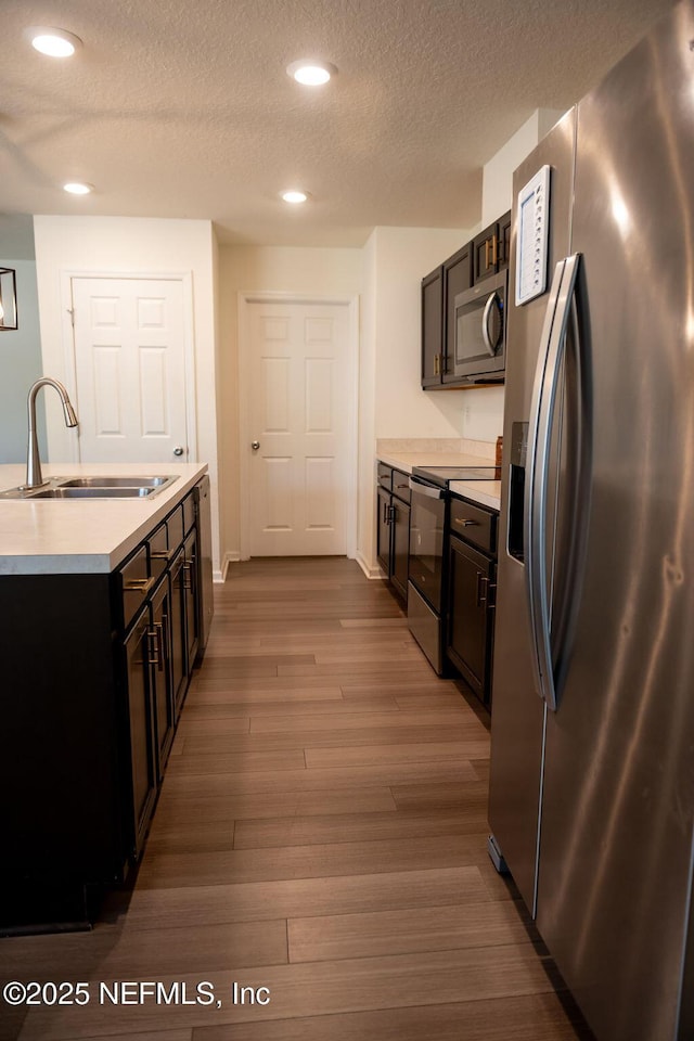 1863 Maxine Branch Way, Jacksonville, FL 32218 - kitchen featuring stainless steel appliances, a sink, light countertops, a textured ceiling, and recessed lighting