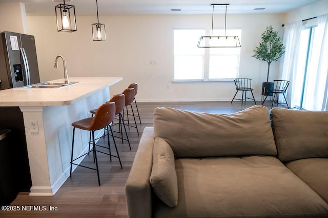 1863 Maxine Branch Way, Jacksonville, FL 32218 - kitchen with a sink, stainless steel fridge with ice dispenser, a breakfast bar, light countertops, and baseboards
