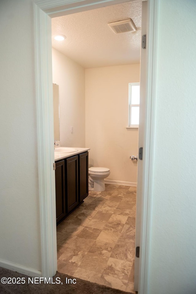1863 Maxine Branch Way, Jacksonville, FL 32218 - bathroom with vanity, toilet, baseboards, and a textured ceiling