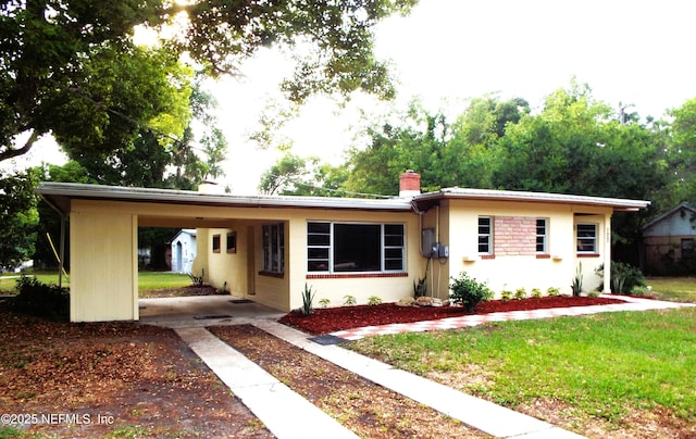 122 Husson Ave, Palatka, FL 32177 - ranch-style home with a chimney, an attached carport, a front yard, dirt driveway, and stucco siding