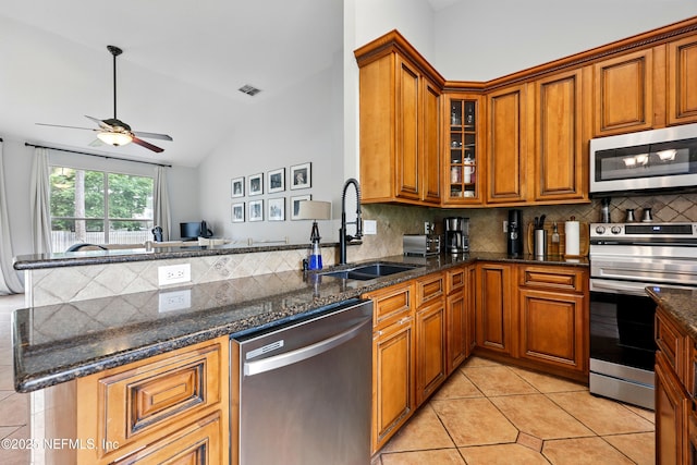 100 Bracken Ct, Saint Johns, FL 32259 - kitchen featuring appliances with stainless steel finishes, a sink, ceiling fan, brown cabinets, and lofted ceiling