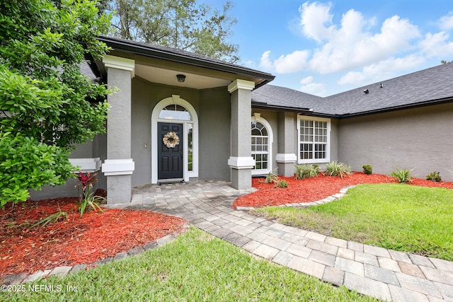100 Bracken Ct, Saint Johns, FL 32259 - view of exterior entry featuring stucco siding, a yard, and roof with shingles