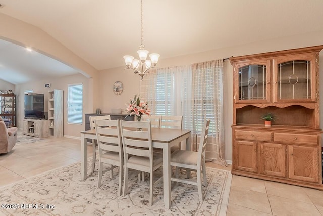 dining room with light tile patterned flooring, lofted ceiling, a chandelier, and baseboards
