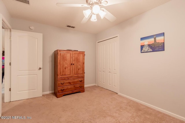 bedroom featuring light colored carpet, a closet, baseboards, and a ceiling fan