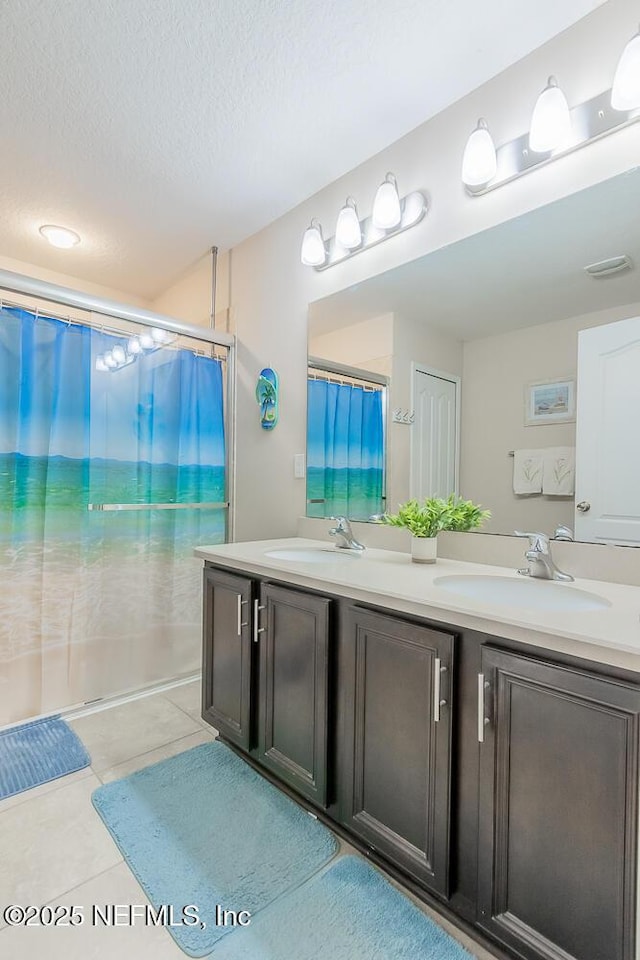 full bathroom with double vanity, tile patterned flooring, a textured ceiling, and curtained shower