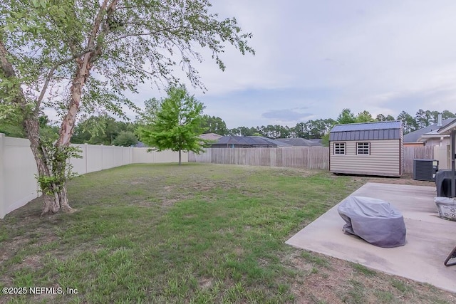 view of yard with a storage shed, a patio area, an outbuilding, and central AC unit