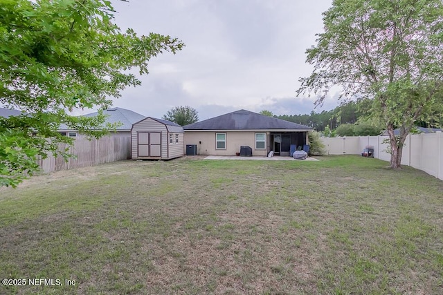 view of yard featuring a shed, a patio, and an outbuilding