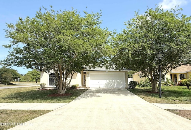 obstructed view of property with concrete driveway, a front lawn, an attached garage, and stucco siding