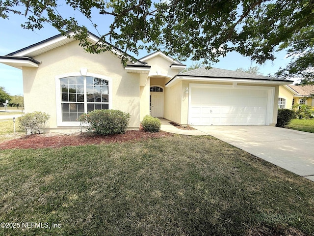 view of front of home featuring stucco siding, a garage, driveway, and a front yard