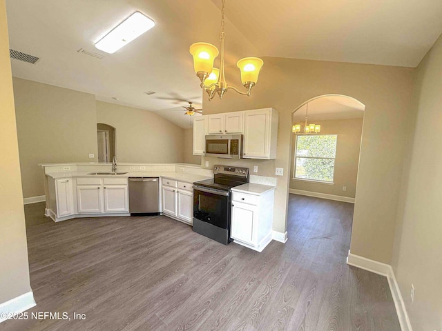 kitchen featuring stainless steel appliances, a chandelier, arched walkways, a ceiling fan, and white cabinets