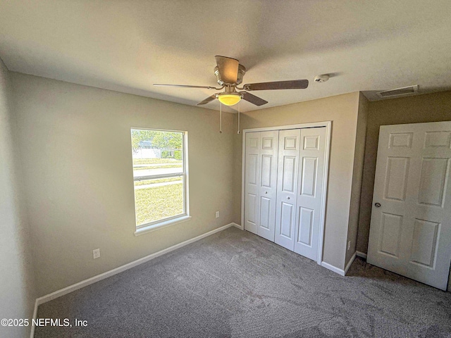 unfurnished bedroom featuring carpet floors, baseboards, a closet, and a ceiling fan