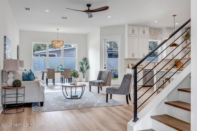 living area with stairway, ceiling fan, healthy amount of natural light, light wood-type flooring, and recessed lighting