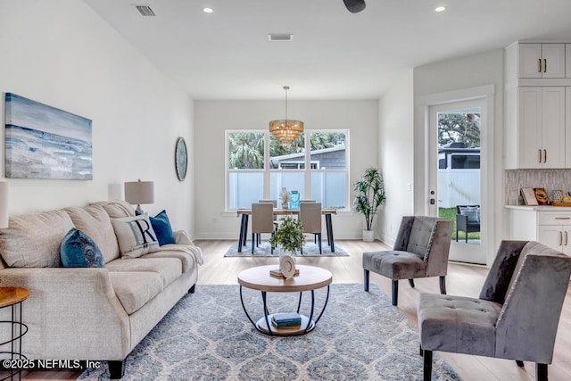 living room featuring healthy amount of natural light, light wood finished floors, recessed lighting, and baseboards