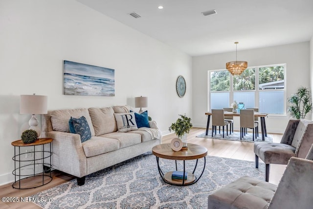 living area with wood finished floors, a chandelier, baseboards, and recessed lighting