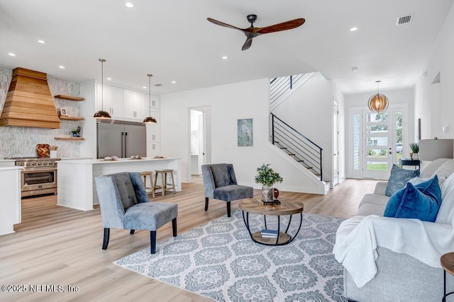 living room with stairway, light wood-type flooring, recessed lighting, and ceiling fan