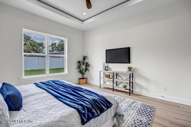 bedroom with multiple windows, wood finished floors, baseboards, and recessed lighting