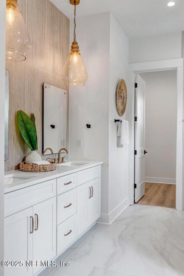 full bath featuring double vanity, baseboards, marble finish flooring, and recessed lighting