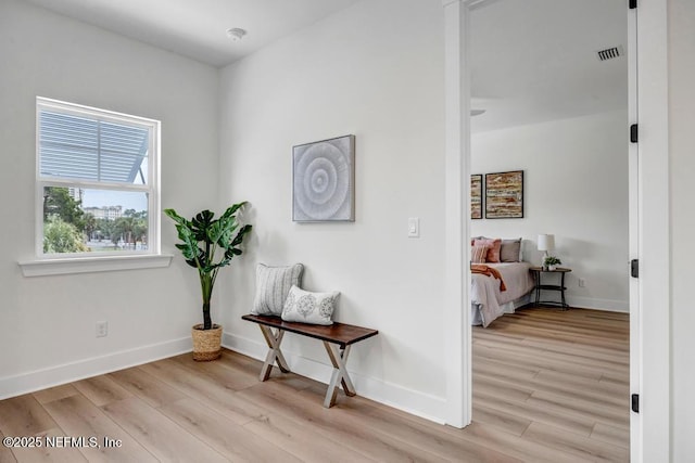 hall with light wood-style flooring and baseboards