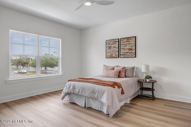 bedroom with light wood-type flooring, baseboards, and ceiling fan