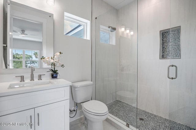 bathroom featuring toilet, a shower stall, vanity, and ceiling fan