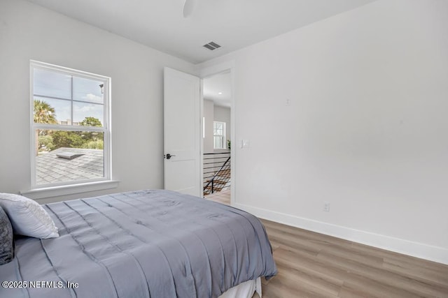 bedroom with baseboards, light wood-style floors, and ceiling fan