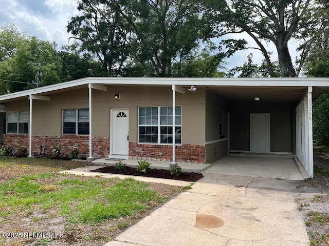 10258 Elmhurst Dr, Jacksonville, FL 32218 - view of front facade featuring concrete driveway, brick siding, and an attached carport