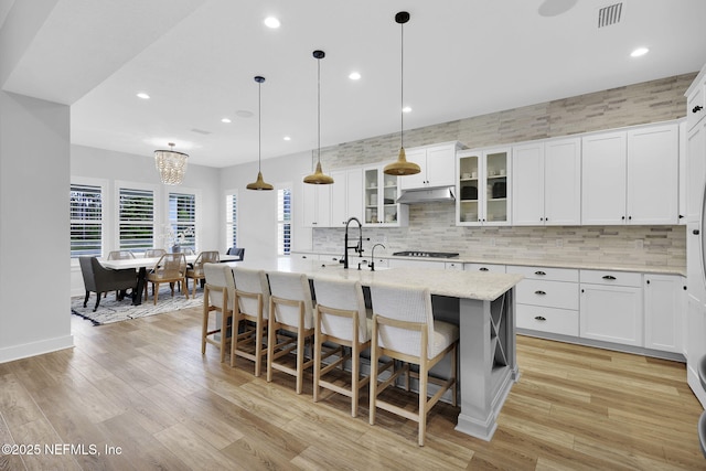 94 Anthem Ridge Dr, Ponte Vedra, FL 32081 - kitchen featuring tasteful backsplash, a breakfast bar, a kitchen island with sink, white cabinetry, and recessed lighting