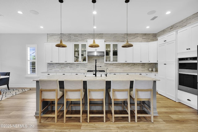 94 Anthem Ridge Dr, Ponte Vedra, FL 32081 - kitchen featuring under cabinet range hood, tasteful backsplash, double oven, a kitchen bar, and recessed lighting