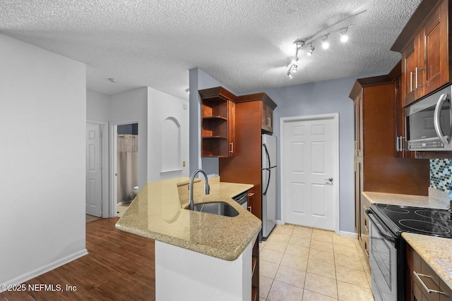 10000 Gate Pkwy Unit 2123, Jacksonville, FL 32246 - kitchen featuring appliances with stainless steel finishes, a sink, a peninsula, open shelves, and light stone counters