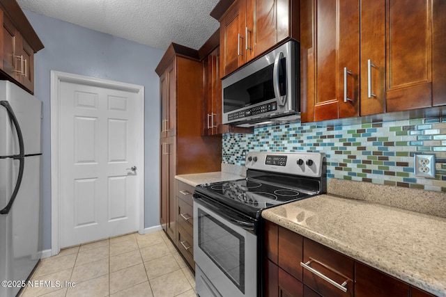 10000 Gate Pkwy Unit 2123, Jacksonville, FL 32246 - kitchen with appliances with stainless steel finishes, backsplash, baseboards, light tile patterned floors, and a textured ceiling