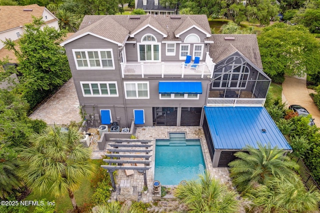 96321 Bay View Dr, Fernandina Beach, FL 32034 - rear view of property featuring a balcony, a patio, an outdoor pool, stone siding, and a jacuzzi