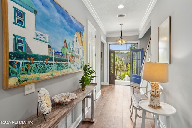 96321 Bay View Dr, Fernandina Beach, FL 32034 - corridor with wood finished floors, ornamental molding, a chandelier, and baseboards