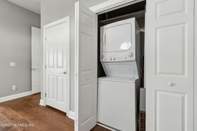 96321 Bay View Dr, Fernandina Beach, FL 32034 - clothes washing area featuring stacked washer / drying machine, dark wood-type flooring, and baseboards