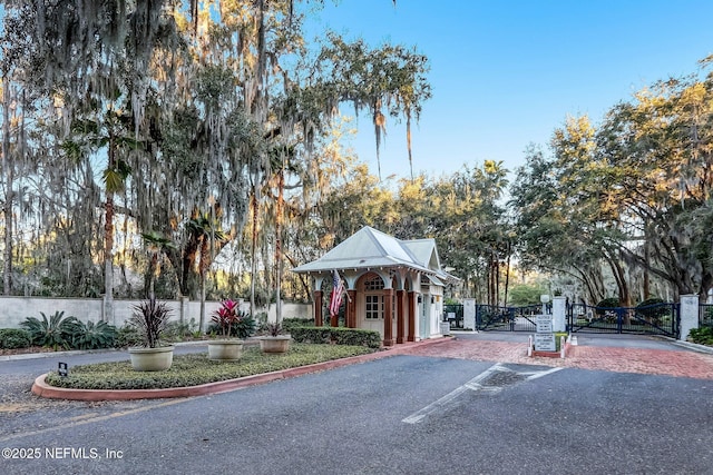 96321 Bay View Dr, Fernandina Beach, FL 32034 - view of asphalt road featuring a gate, curbs, and a gated entry