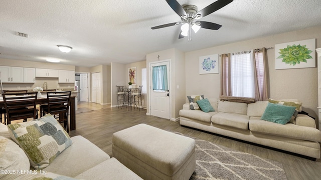 11428 Rustic Pines Cir E, Jacksonville, FL 32257 - living room featuring a textured ceiling, wood finished floors, a ceiling fan, and baseboards