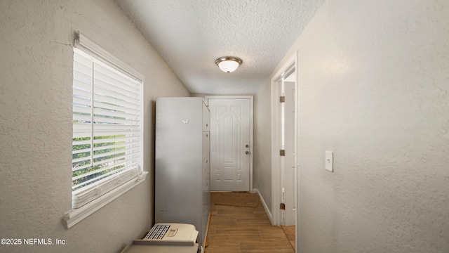 11428 Rustic Pines Cir E, Jacksonville, FL 32257 - corridor with a textured ceiling, a textured wall, and baseboards
