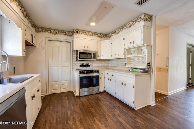 5476 Waterside Dr, Jacksonville, FL 32210 - kitchen featuring stainless steel appliances, a sink, dark wood-type flooring, light countertops, and recessed lighting