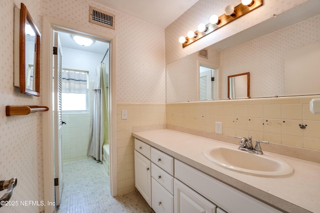 5476 Waterside Dr, Jacksonville, FL 32210 - full bathroom featuring vanity, tile walls, shower / bath combo, a wainscoted wall, and tile patterned floors