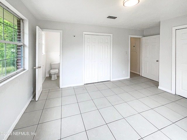 unfurnished bedroom with light tile patterned flooring and baseboards