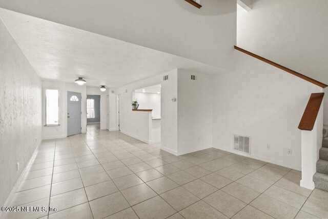 2885 Sand Castle Ln, Jacksonville, FL 32233 - unfurnished living room featuring light tile patterned floors, stairs, and baseboards
