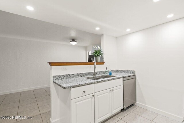 2885 Sand Castle Ln, Jacksonville, FL 32233 - kitchen with dishwasher, a sink, light tile patterned floors, white cabinetry, and baseboards