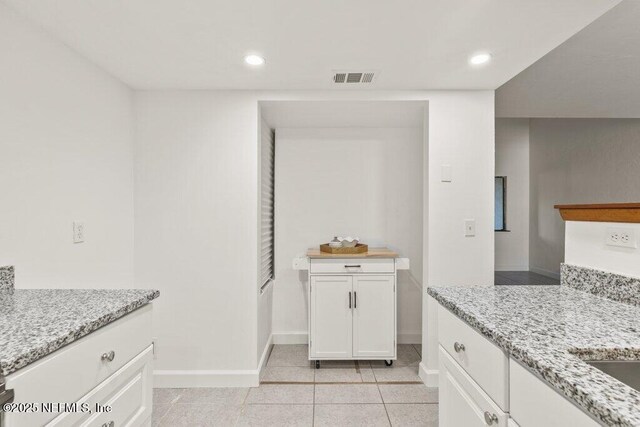 2885 Sand Castle Ln, Jacksonville, FL 32233 - kitchen featuring baseboards, white cabinetry, recessed lighting, light stone countertops, and light tile patterned floors