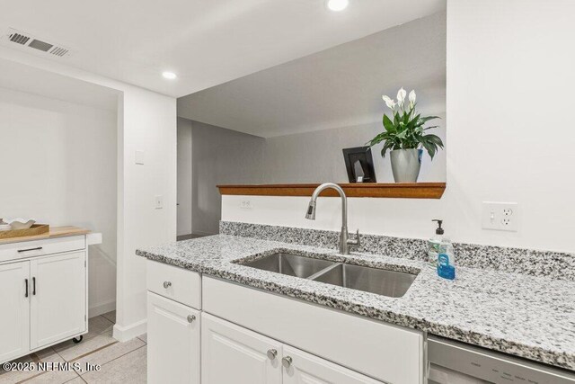 2885 Sand Castle Ln, Jacksonville, FL 32233 - kitchen with a sink, stainless steel dishwasher, white cabinetry, light stone countertops, and recessed lighting