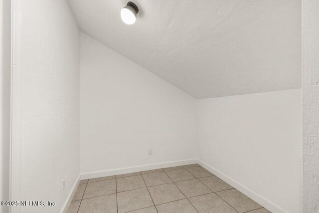 2885 Sand Castle Ln, Jacksonville, FL 32233 - additional living space with vaulted ceiling, baseboards, and light tile patterned floors