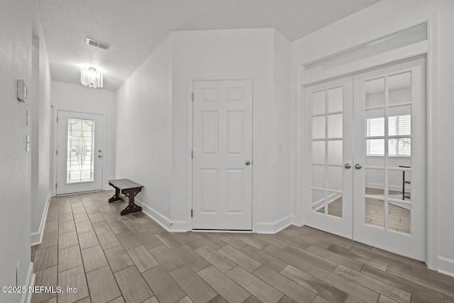 107 Park Lake Dr, Ponte Vedra, FL 32081 - foyer entrance with french doors, wood finish floors, baseboards, and a textured ceiling
