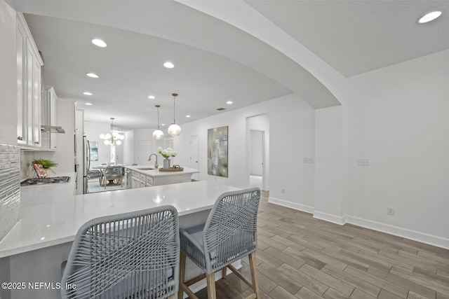 107 Park Lake Dr, Ponte Vedra, FL 32081 - kitchen with a sink, light countertops, recessed lighting, a peninsula, and wood finish floors