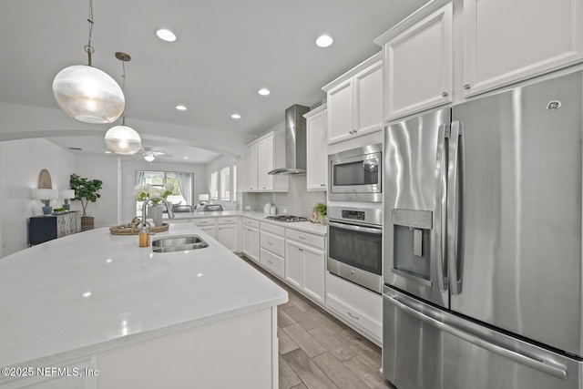 107 Park Lake Dr, Ponte Vedra, FL 32081 - kitchen featuring appliances with stainless steel finishes, wall chimney range hood, a sink, white cabinets, and recessed lighting