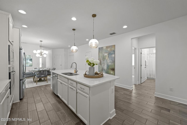107 Park Lake Dr, Ponte Vedra, FL 32081 - kitchen featuring a sink, appliances with stainless steel finishes, wood tiled floors, a chandelier, and white cabinetry