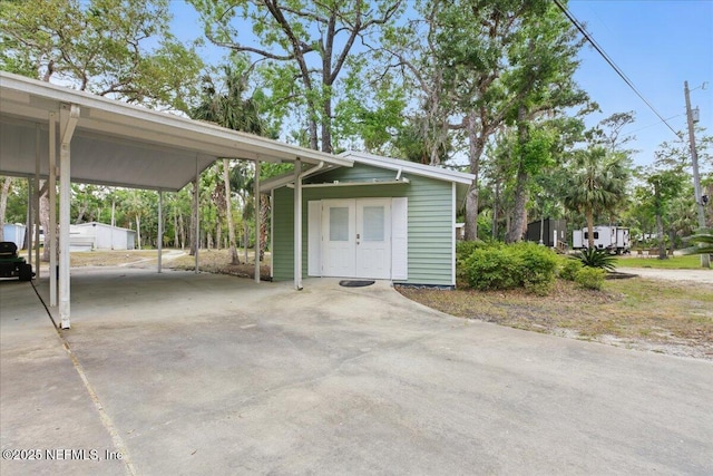 1418 Palm St NE, Steinhatchee, FL 32359 - view of side of property featuring driveway, a carport, and an outdoor structure